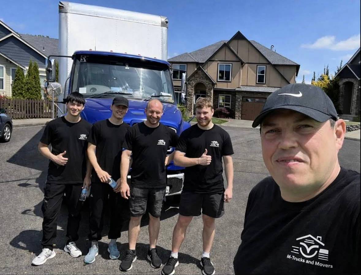 M-Trucks and Movers crew of five in front of branded truck at large residence