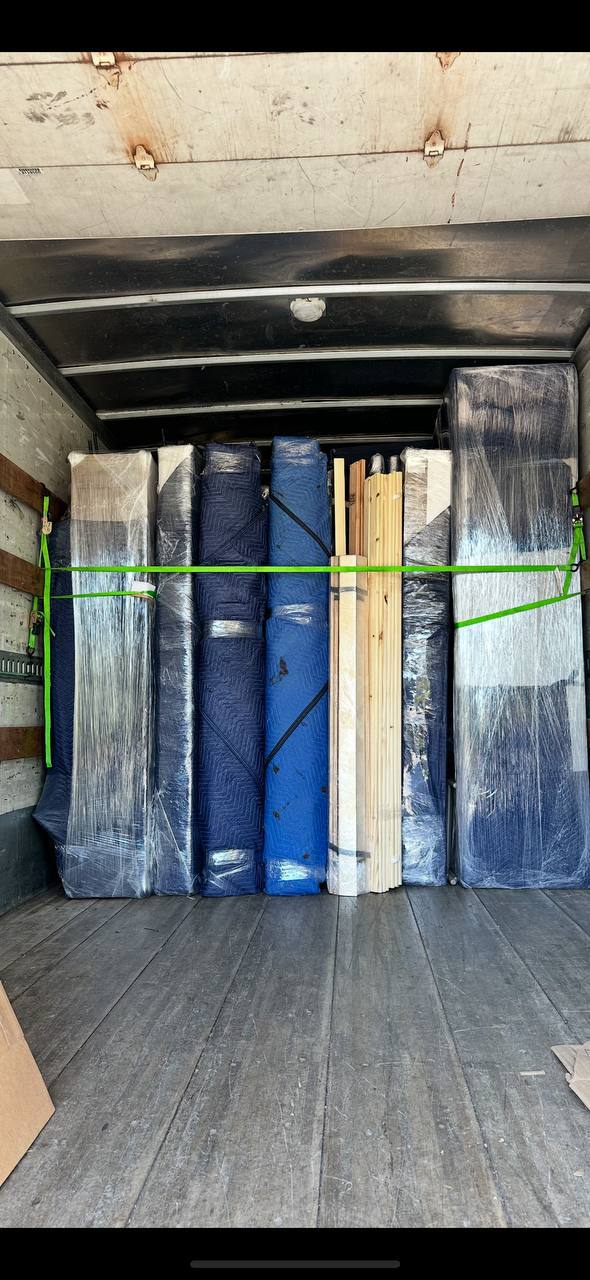Inside view of moving truck loaded with strapped wrapped furniture