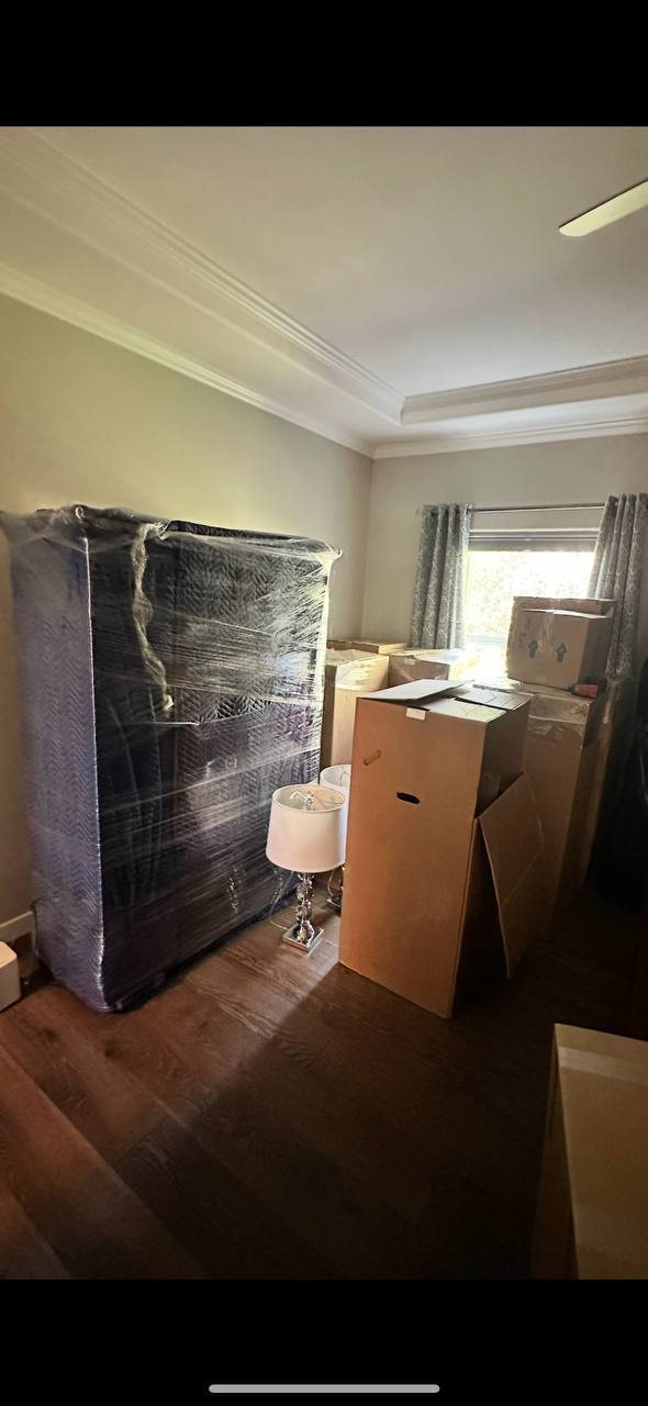 Wrapped mattress and packed boxes in room