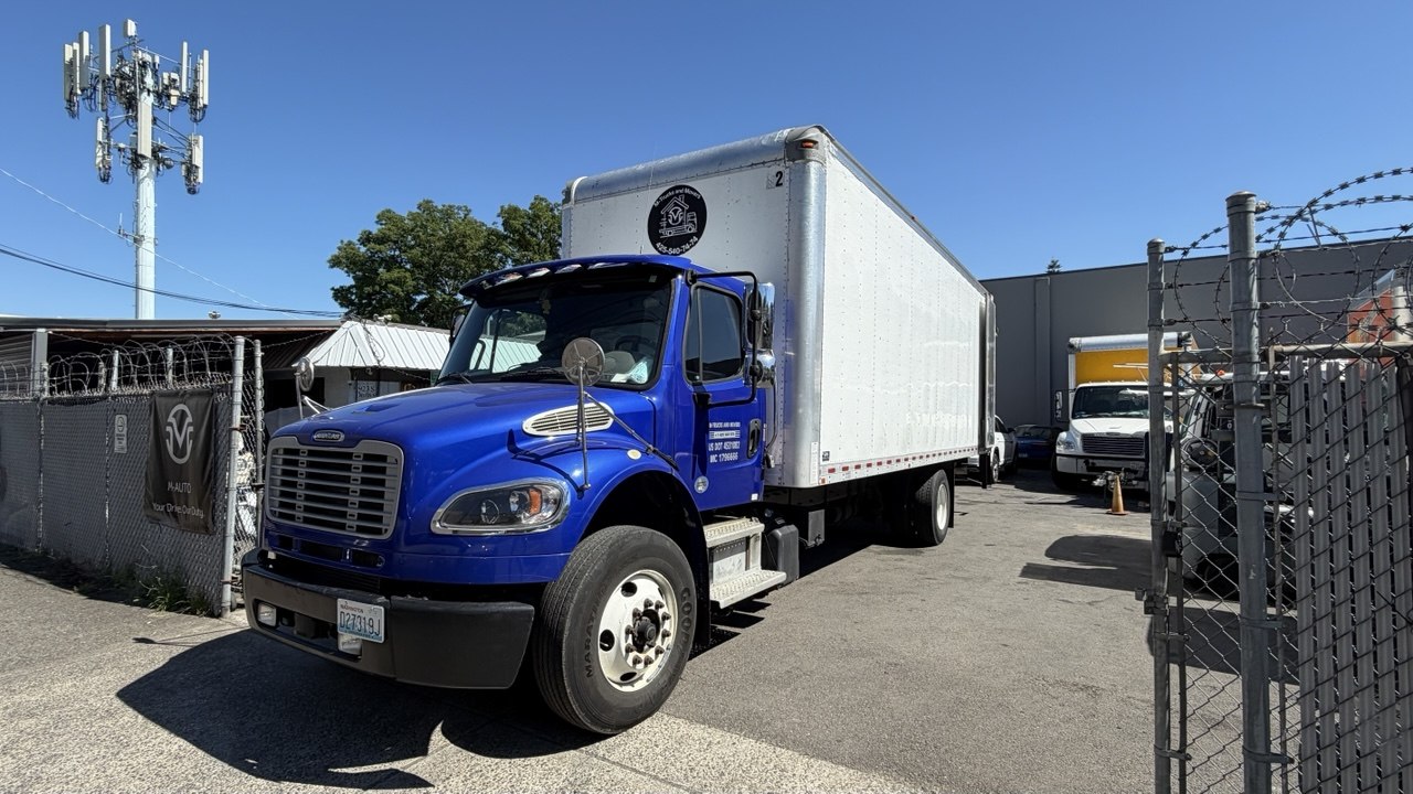 M-Trucks and Movers branded blue moving truck with company emblem